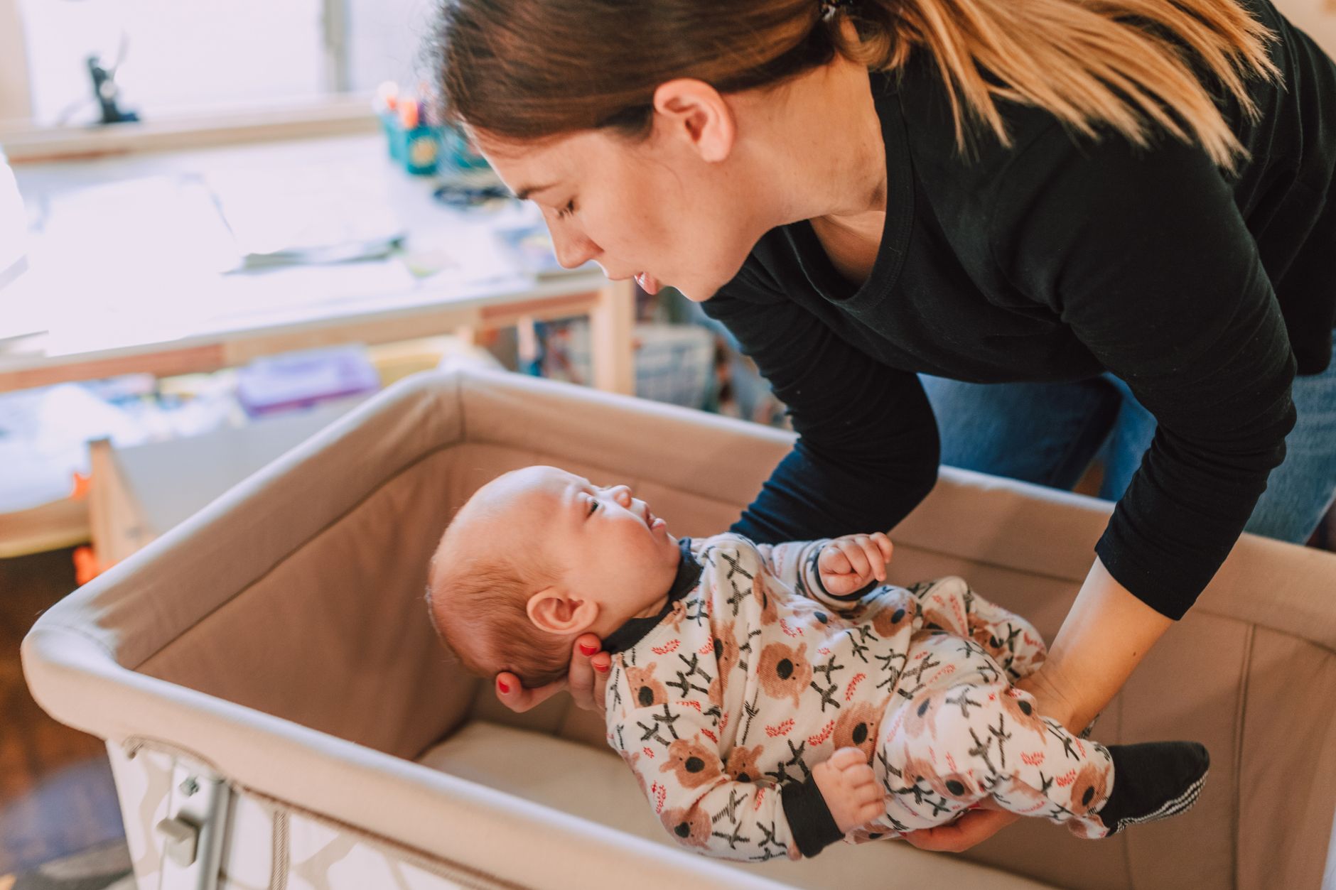 A caregiver gently holding and caring for an infant in a quiet nursery